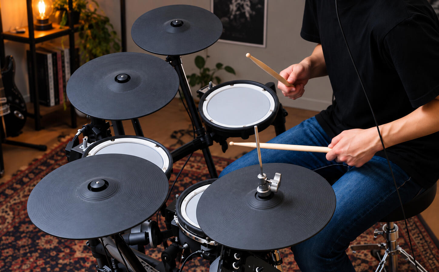 A drummer seated at a mesh-head electronic drum kit in a living room, sticks mid-stroke over the snare and hi-hat.
